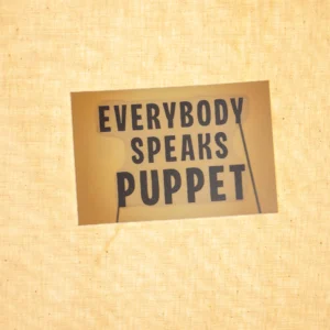 A rectangular yellow sticker with 'Everybody Speaks Puppet' written on it in black.